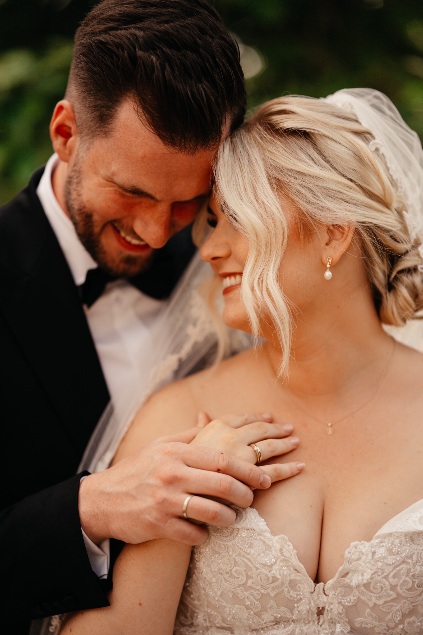 Brautpaar lacht Stirn an Stirn bei der Hofhochzeit