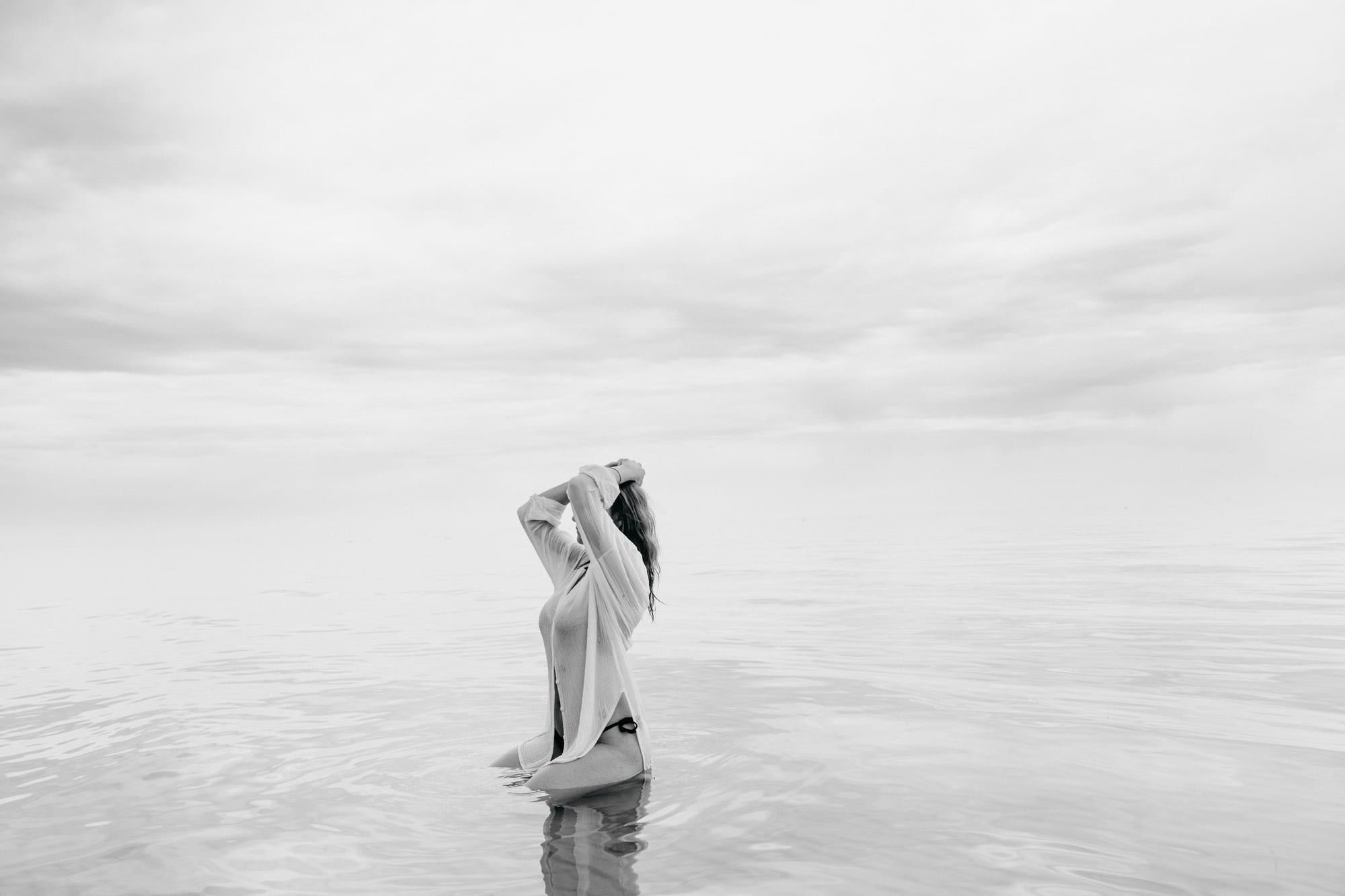 Lena als kleine Figur im diesigen Meer der Ostsee, kurz bevor das Gewitter aufzog